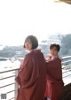 A couple of women standing next to each other on a balcony.