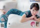 A woman laying on top of a white couch.