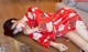 A woman in a red kimono laying on a table.