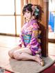 A woman in a kimono sitting on the floor.