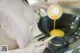 A woman in a pink lingerie is preparing food in a wok.