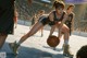 A group of young women playing a game of basketball.