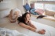 A woman laying on a bed in a white lingerie.