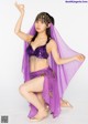 A woman in a purple belly dance outfit posing for a picture.