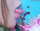 A close up of a woman's tongue sticking out of a flower.